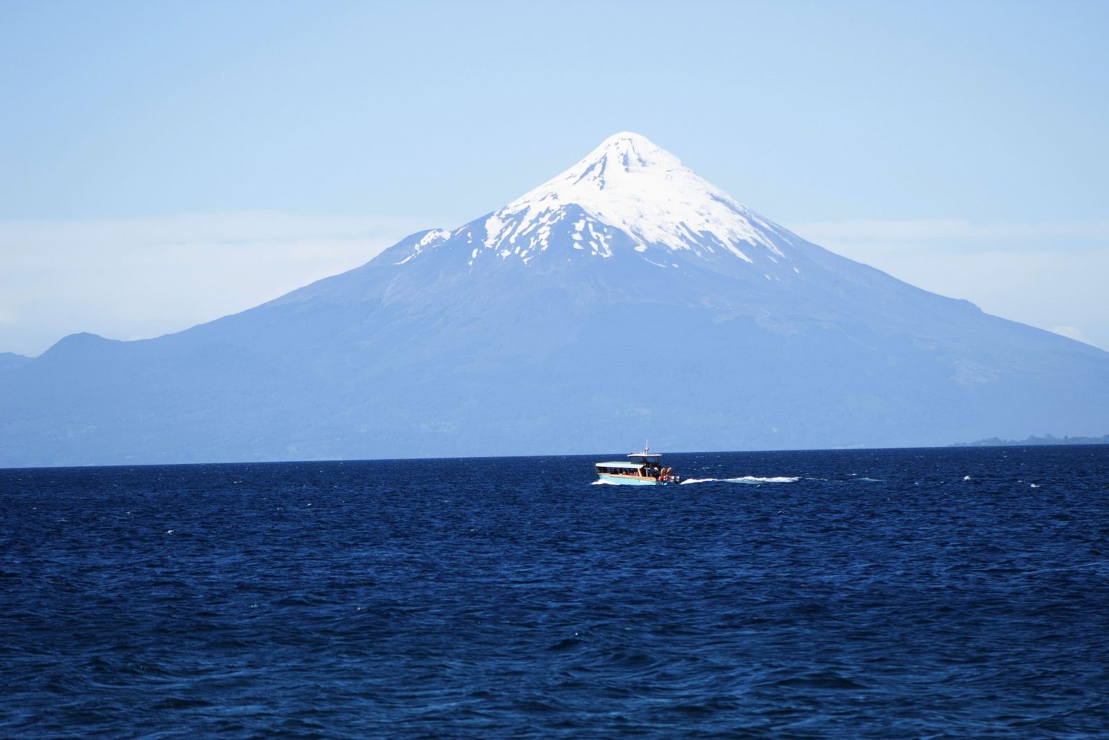 La lancha Lago Llanquihue navegando en el lago frente al volcán Osorno nevado